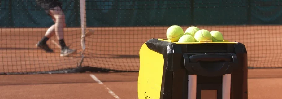 Tennis player playing backhand slice with a tennis ball machine